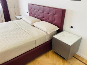 um quarto com uma cama grande e uma cabeceira de cama roxa em BILOCALE_TORINO_DELUXE em Turim