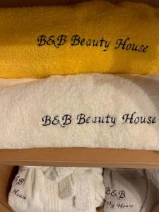 une étagère de serviettes avec les mots bebb Beauty house et bebb Beauty house dans l'établissement B&B Beauty House, à Cesena