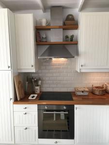 a kitchen with white cabinets and a stove top oven at Amelotte in Nieuwpoort