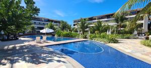 a swimming pool in front of a building at Malawi Muro Alto - Flat 103H Térreo in Porto De Galinhas