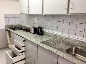 a kitchen with a sink and a counter top at La Péninsule Town Apartment No 5 in Curepipe