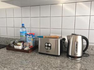 a toaster and a coffee maker on a kitchen counter at La Péninsule Town Apartment No 5 in Curepipe +16 photos