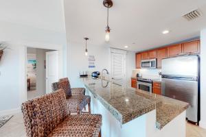 a kitchen with a counter and two chairs in it at The Grand Sandestin II in Destin