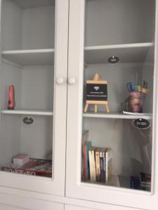 a white cupboard with books in it at La Péninsule Town Apartment No 5 in Curepipe