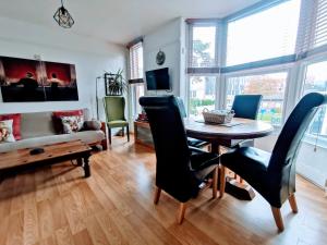 a living room with a table and chairs and a couch at Victoriana Apartment - Private Balcony in Stratford-upon-Avon