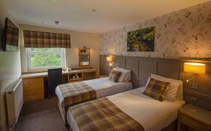 a hotel room with two beds and a desk at Royal Victoria Hotel Snowdonia in Llanberis +37 photos