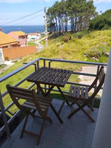a picnic table and two chairs on a balcony at Apartamento Peregrinos Por la Costa Camino Portugués As Casetas in Rosal
