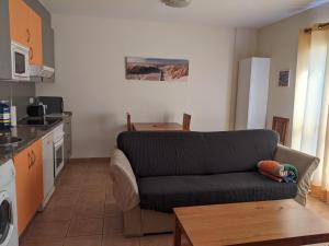 a living room with a couch and a kitchen at Be Cotillo Apartment in El Cotillo