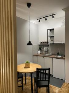 a kitchen with a wooden table and chairs in a room at Apartmani Sombor in Sombor