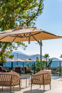 two chairs and a table with an umbrella at Sundia Exclusive By Liberty Fethiye Adults Only in Fethiye