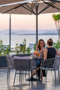 two women sitting at a table under an umbrella at Sundia Exclusive By Liberty Fethiye Adults Only in Fethiye