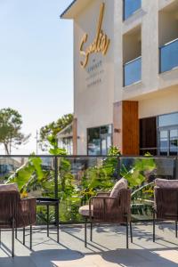 four chairs and a table in front of a building at Sundia Exclusive By Liberty Fethiye Adults Only in Fethiye