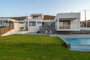 a house with a swimming pool and a yard at Agia Pelagia Villas in Agia Pelagia