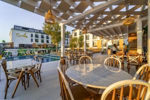 an outdoor patio with tables and chairs and a pool at Sundia Exclusive By Liberty Fethiye Adults Only in Fethiye