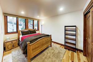 a bedroom with a wooden bed and a window at Tamarak 6 in Snowmass
