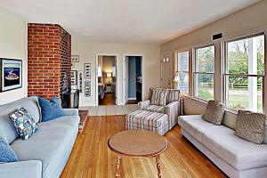 a living room with a couch and chairs and a table at Harbor Point Cottage in Bourne