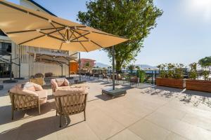 a patio with chairs and umbrellas on a patio at Sundia Exclusive By Liberty Fethiye Adults Only in Fethiye