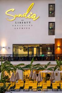 a restaurant with chairs and umbrellas in front of a building at Sundia Exclusive By Liberty Fethiye Adults Only in Fethiye