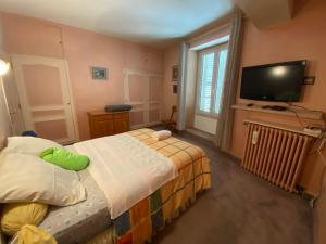 a small bedroom with a bed and a flat screen tv at Four A Ban in Mer