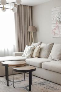 ein Wohnzimmer mit einem weißen Sofa und einem Tisch in der Unterkunft Bulevar Apartmani in Pale