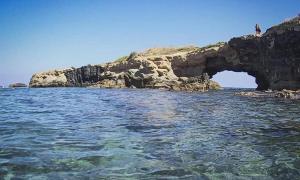 una grotta in acqua vicino a un'isola rocciosa di Casa Mare Costa Saracena - Castelluccio ad Agnone Bagni