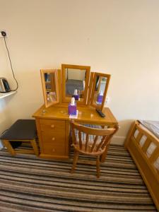 a bedroom with a desk with a bed and a mirror at Four Seasons Guest House in Canterbury