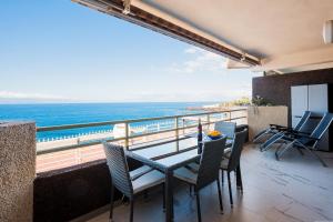 a balcony with a table and chairs and the ocean at CASA NELKA in Puerto de Santiago