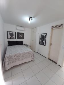 um quarto com uma cama e duas fotografias na parede em Casa em Condomínio 2 suítes casa 03 em Juazeiro do Norte