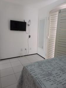 ein Schlafzimmer mit einem Bett und einem TV an der Wand in der Unterkunft Casa em Condomínio 2 suítes casa 03 in Juazeiro do Norte