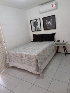 a bedroom with a bed with a white comforter at Casa em Condomínio 2 suítes casa 03 in Juazeiro do Norte