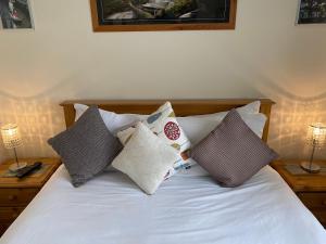 Una cama con cuatro almohadas encima. en Four Seasons Guest House en Canterbury