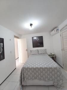 a bedroom with a bed and a tv on the wall at Casa em Condomínio 2 suítes casa 03 in Juazeiro do Norte