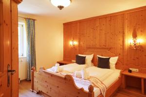 a bedroom with a large bed with a wooden wall at Sonnenschein in Wertach