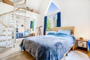 a bedroom with a bed with a blue blanket at Enchanted Cottage in Vashon