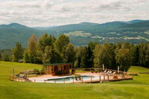 a house on a hill with a swimming pool at Chalet Paradis de Charlevoix in Baie-Saint-Paul