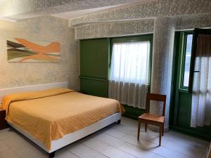 um quarto com uma cama, uma janela e uma cadeira em Gemini Studios em Florença
