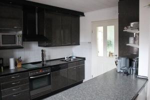 una cocina con armarios de color marrón oscuro y fregadero en Ferienwohnung Lachmayr, en Geltendorf