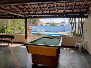 a pool table on a patio with a swimming pool at Sobrado Estiloso in Caraguatatuba