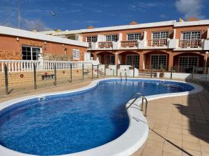 een groot zwembad voor een gebouw bij Apartamento Gustamar 11 in Caleta De Fuste