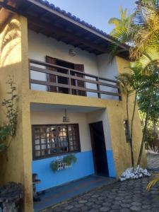 une maison avec un palmier en face dans l'établissement Sobrado Estiloso, à Caraguatatuba
