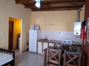 a kitchen with a white refrigerator and a table at Guardalaola Patagonia Puelche in Las Grutas +10 photos