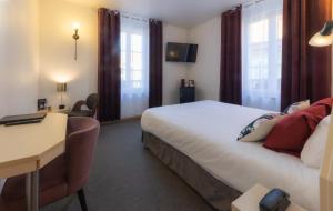 Habitación de hotel con cama, escritorio y ventanas en Grand Hôtel Du Nord, en Vesoul