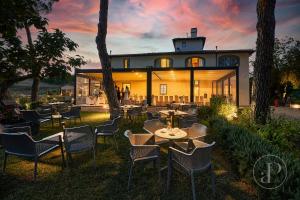 un restaurant avec des tables et des chaises en face d'un bâtiment dans l'établissement Resort 37, à Rignano sullʼArno