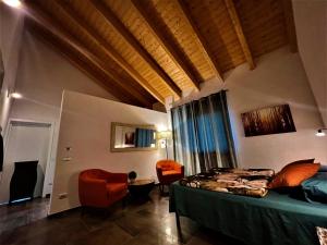 a bedroom with a bed and chairs in a room at Cascina Malinverni in Rocchetta Palafea