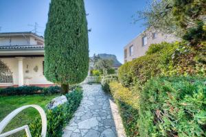 einen Garten mit einem Baum und einem Steinweg in der Unterkunft ApartmentsGarda - Residenza Bouganville in Garda