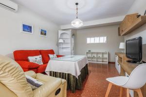a living room with a couch and a tv at Apartamentos Alameda del Tajo I Parquing Centro in Ronda