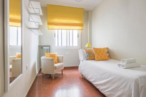 une petite pièce avec un lit et une chaise dans l'établissement Apartamentos Alameda del Tajo I Parquing Centro, à Ronda
