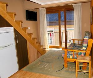 a kitchen with a staircase and a living room at Apartamentos Barrosa II in Portonovo
