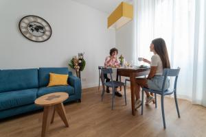 twee vrouwen aan een tafel in een woonkamer bij Nuances The Colosseum Apartment in Rome