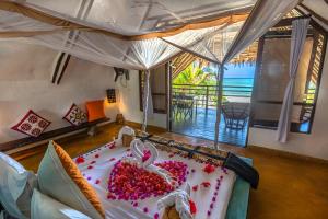 a bedroom with a bed with pink flowers on it at Zoi Boutique Hotel Zanzibar ex Sunshine Hotel in Matemwe